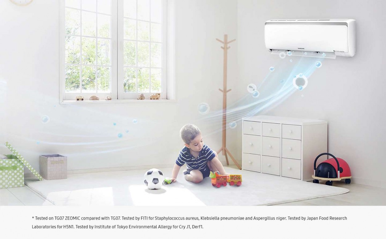 Ambiente de quarto de criança, com uma janela e brinquedos. Um menino brinca de carrinho. Ar-Condicionado Digital Inverter na parede, funcionando. Dele saem bolhas azuis para representar a função de manter o ar sempre limpo.